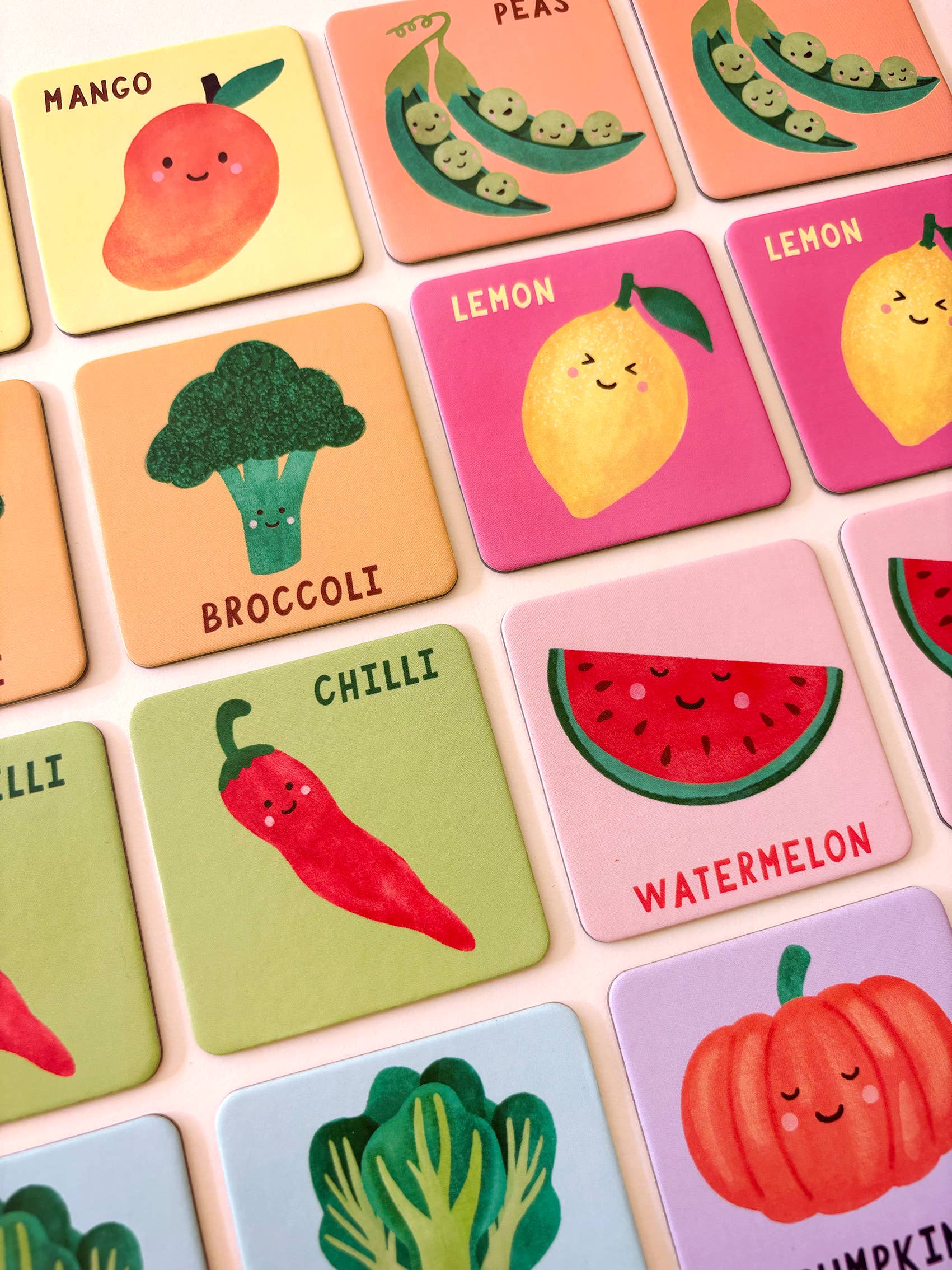 The Fruit and Veg Memory & Matching Game by Lauren Sissons Studio is a fun, educational gift featuring colorful cards with cute fruit and vegetable illustrations—mango, peas, broccoli, lemon, chili, watermelon, and pumpkin—all labeled with their names.
