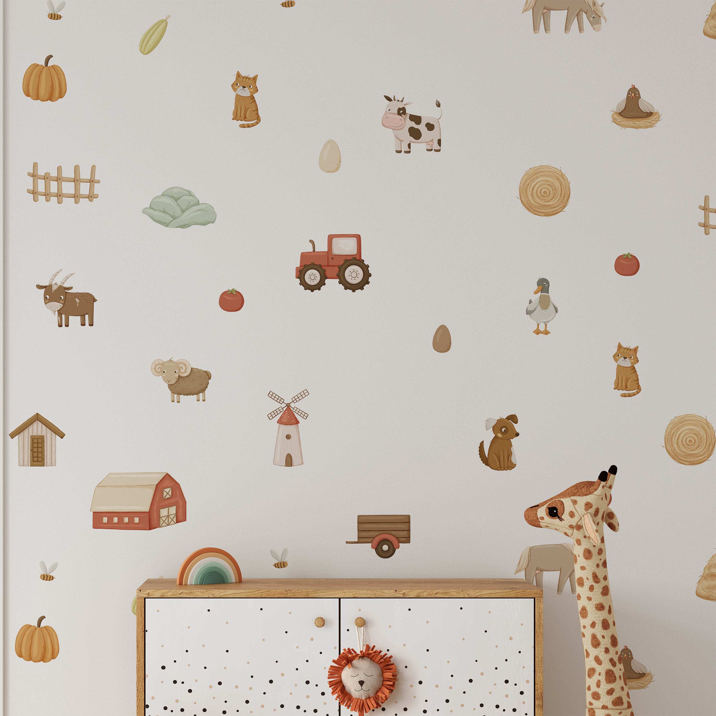A nursery wall adorned with Baby Belle's On The Farm Wall Decals, featuring cows, goats, dogs, ducks, a tractor, barn, windmill, and plants. A plush giraffe stands by a white cabinet for charming decor.