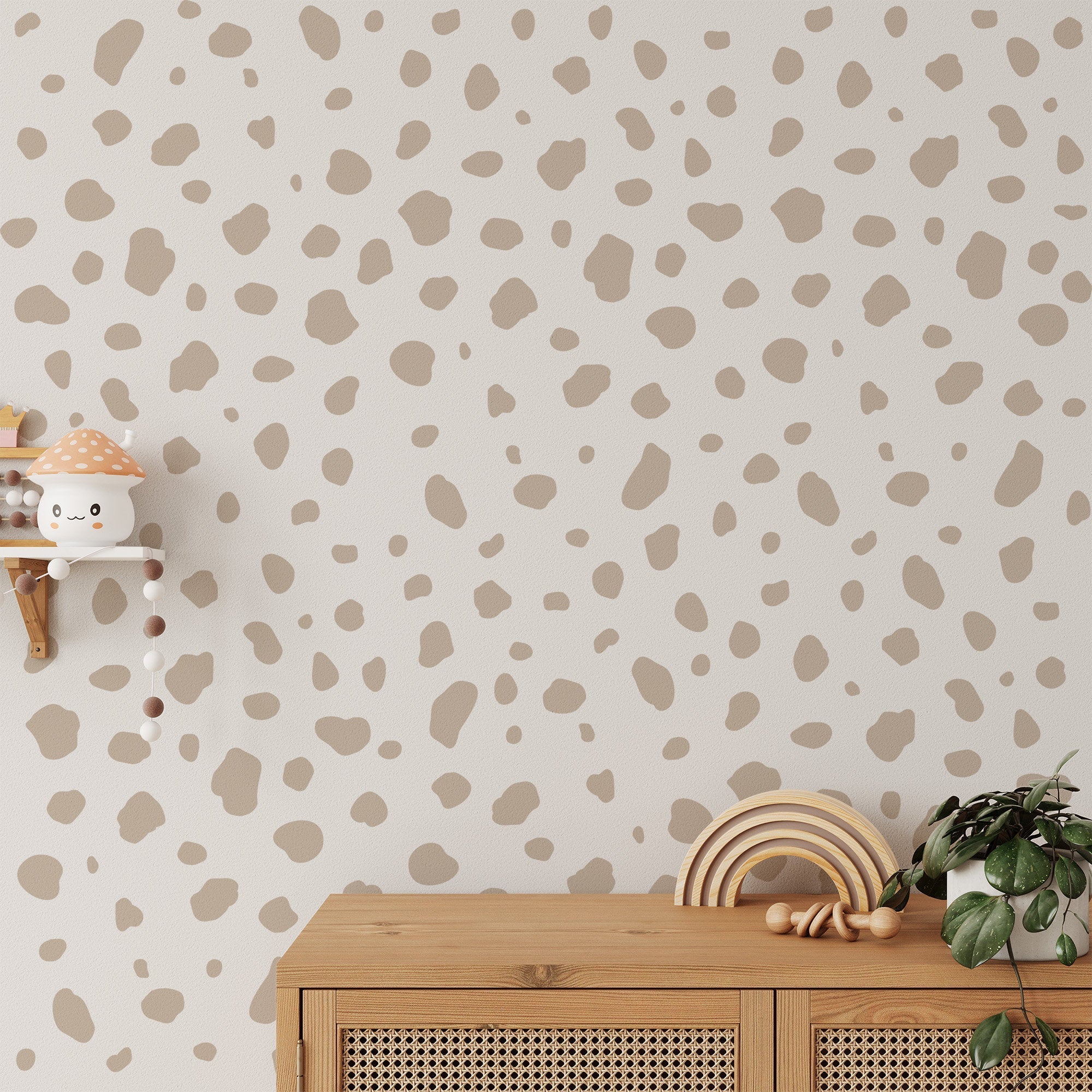 A wooden shelf with a toy mushroom and bead garland is mounted on a wall decorated with My Stores Dalmation Spot Large Stickers. Below, a wooden cabinet displays decorative wooden toys, crafting a playful and cozy atmosphere.
