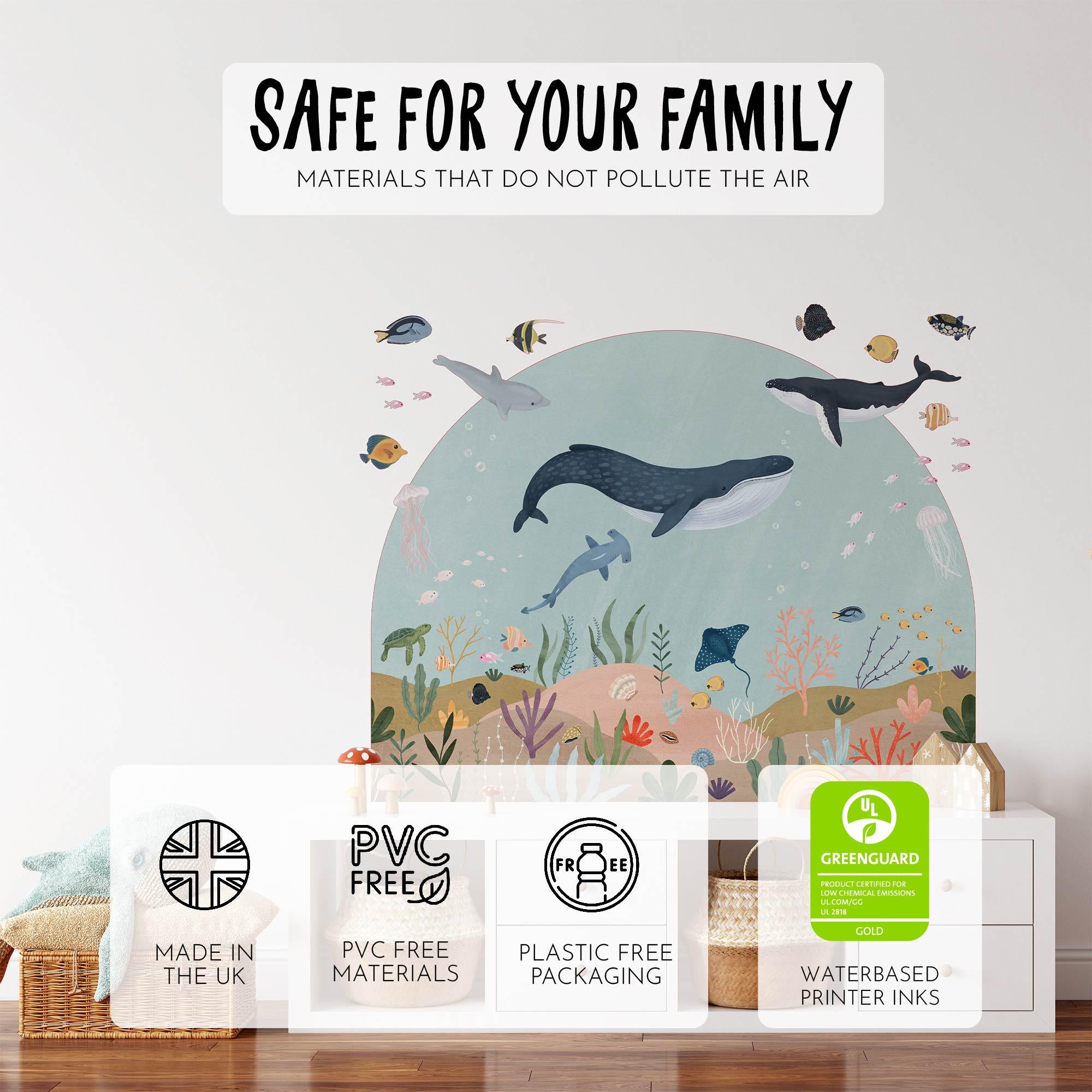 A childrens room wall features an ocean-themed mural with Sea Animals Arch Wall Sticker by My Store, showcasing eco-friendly icons: made in the UK, PVC-free, plastic-free packaging, GREENGUARD certified, self-adhesive stickers, and water-based inks.