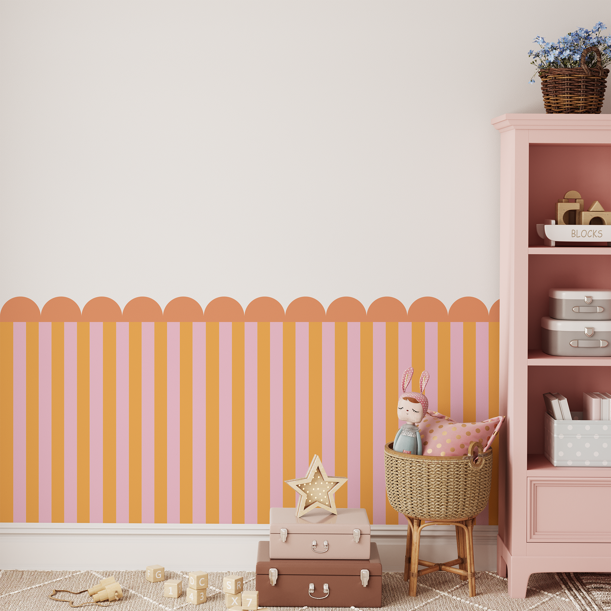 A pastel-themed kids’ room with peach and pink vertical striped wallpaper, a pink shelf, wicker basket with a doll, stacked suitcases, and toys on a light wooden floor.