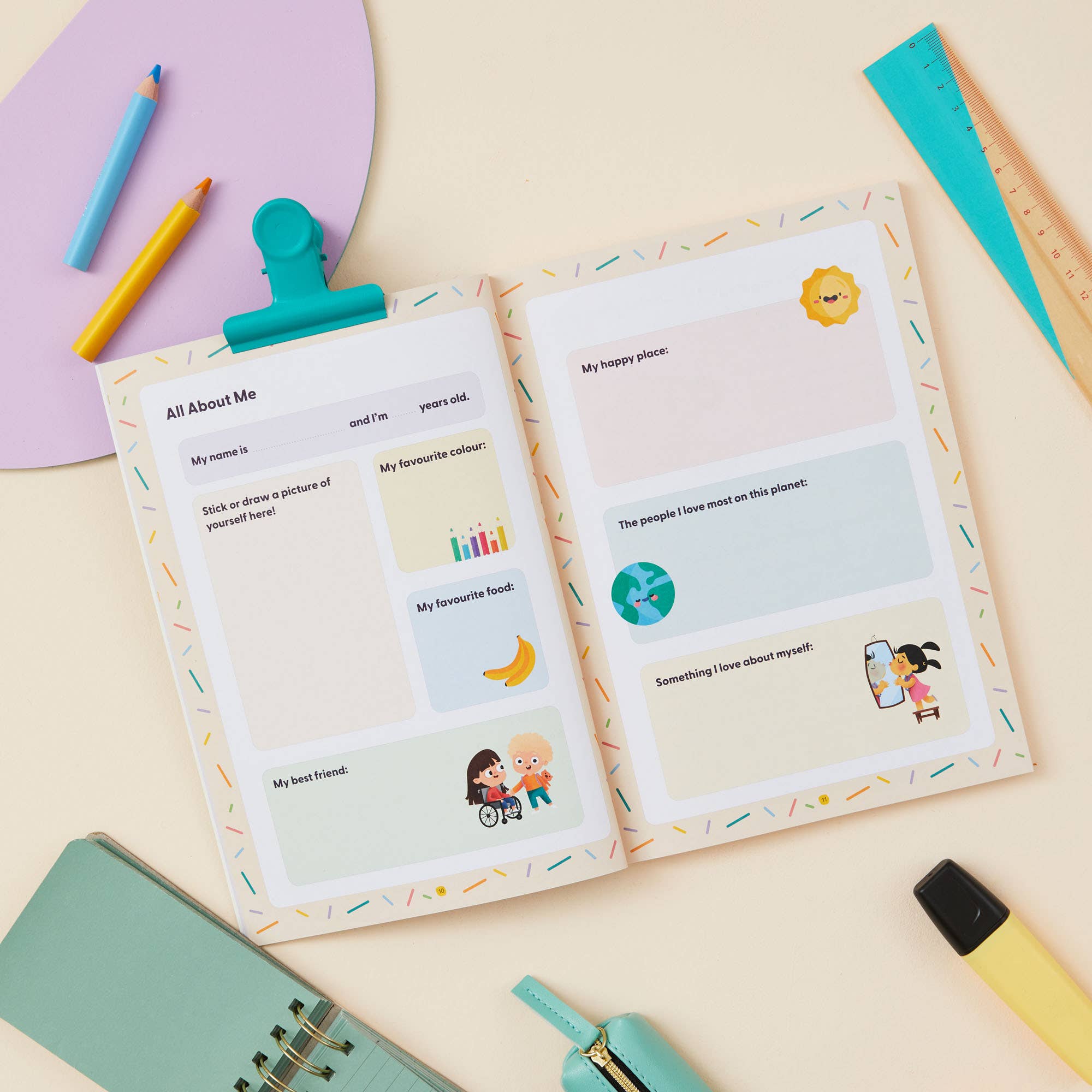 The My Mindful Me Journal Early Years Edition by Mindful Champs sits on a desk with colorful stationery, featuring prompts and illustrations for kids to share about themselves, their favorites, and loved ones.