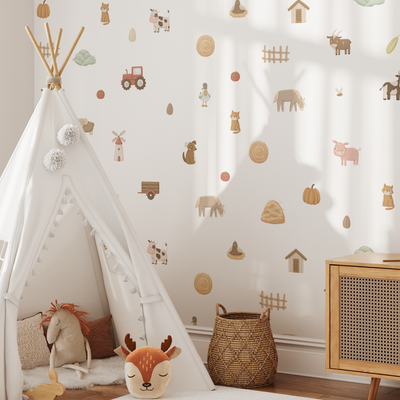 A cozy children’s room features Baby Belle's On The Farm Wall Decals with cows, sheep, chickens, a tractor, and fences—perfect nursery decor alongside a white play tent, plush animal toys, woven basket, and cabinet under sunny light.