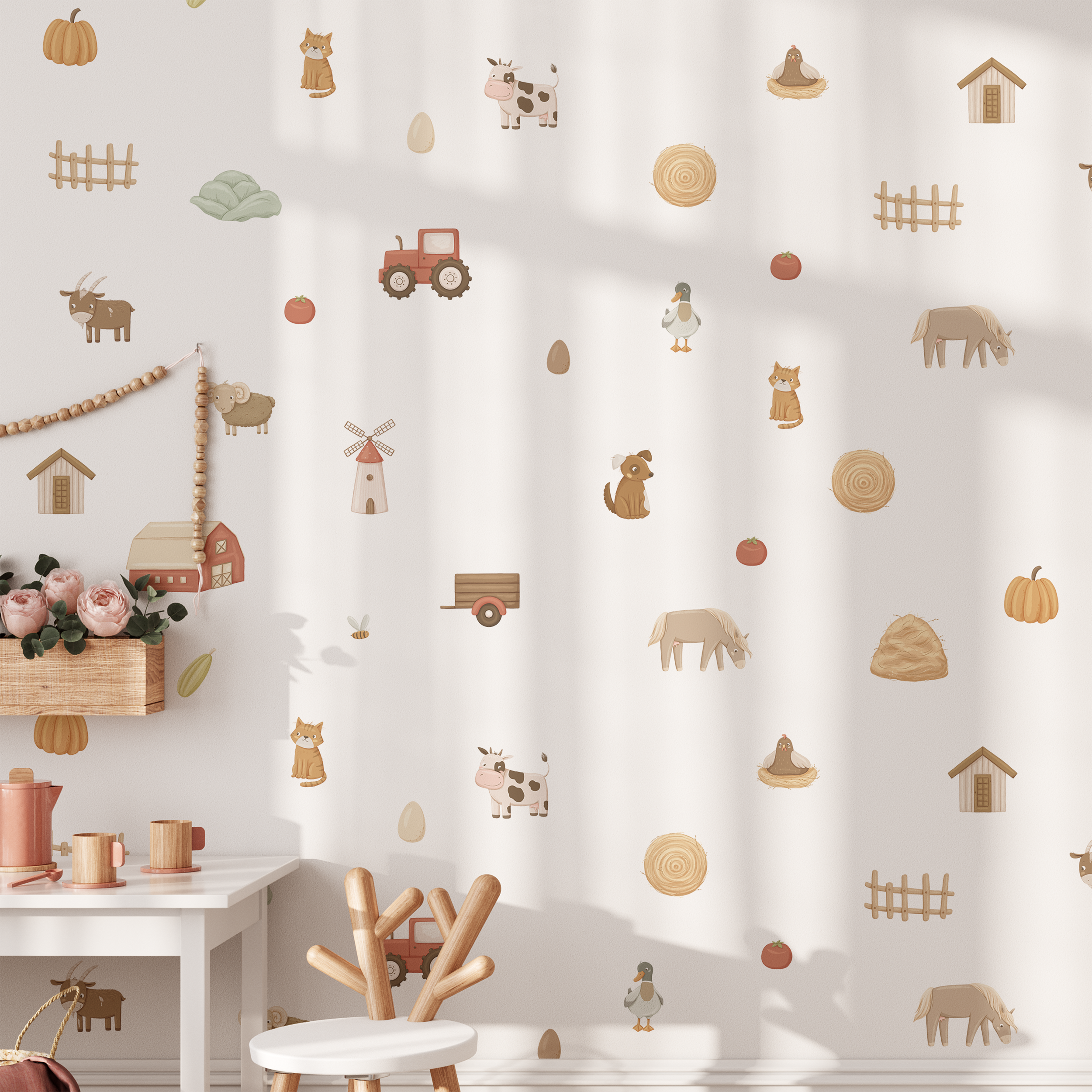 A bright nursery with a small white table and pink flowers is decorated with Baby Belle’s On The Farm Wall Decals, featuring playful animals, a tractor, barn, eggs, pumpkins, hay bales, and fences.