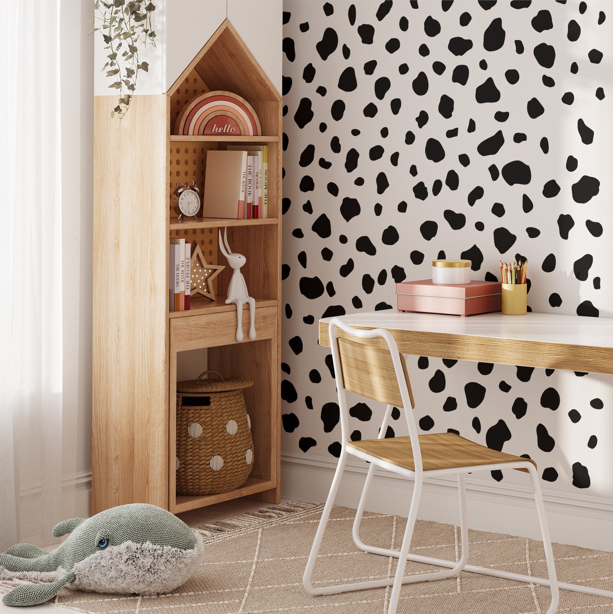 A cozy childrens study room has a wooden desk with a white chair, a house-shaped bookshelf with toys, and My Store Dalmatian Spot Stickers on dotted black-and-white wallpaper. A plush whale toy lies on the beige geometric rug by the window.