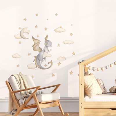 A cozy childrens room with a wooden chair and crib features My Stores Dragon Stickers, including whimsical watercolour dragons, stars, clouds, and a crescent moon on the wall. A fluffy blanket is draped over the chair while a pillow rests in the crib.