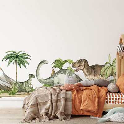 A cozy childrens bedroom showcases My Stores Dinosaur Nursery Stickers, featuring vibrant decals of dinosaurs, palm trees, and mountains. The room is adorned with an orange and beige bedding set, a playful cat pillow on the bed, and a plush toy on the floor for charming nursery decor.