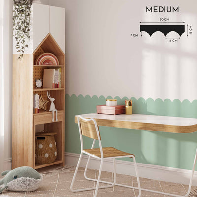 A cozy childrens room showcases a My Store Scalloped Wall Stencil in green, removable for ease. It features a wooden study desk, white chair, house-shaped bookshelf for books and toys, and a soft toy on a patterned rug. Wall art dimensions are prominently displayed.