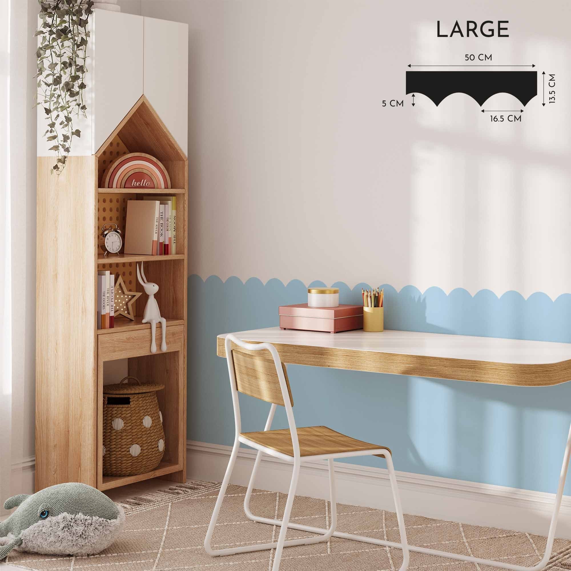 A childrens room includes a wooden desk with a chair, a house-shaped tall shelf, and My Stores Scalloped Wall Stencil in blue on the walls. The floor features a geometric patterned rug and a plush whale toy, with wall measurement details visible.
