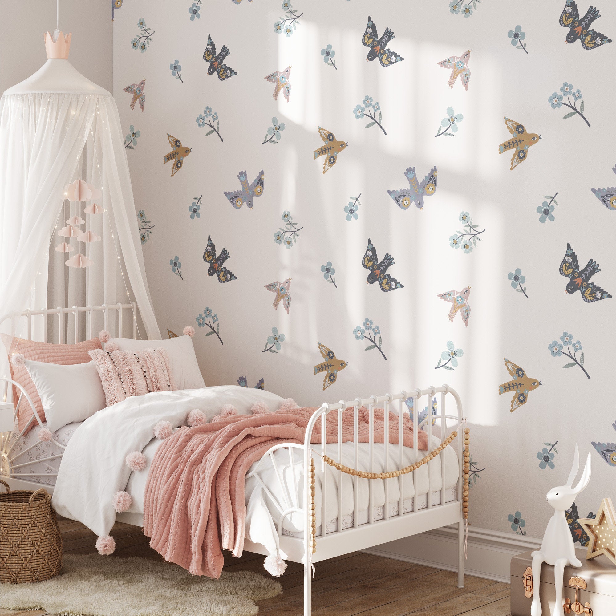 A cozy bedroom features a white metal bed with pink pillows and a fluffy blanket. Butterfly and floral Summer Mood Wall Stickers by My Store adorn the walls. A canopy hangs above, with a woven basket on the floor as sunlight streams in, creating a serene atmosphere.