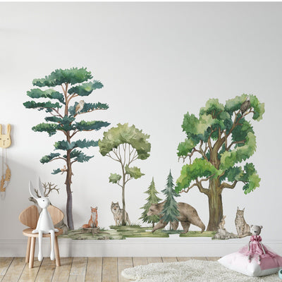 A childrens room boasts a wall mural of forest scenes featuring a fox, wolf, bear, and owl. My Stores Woodland Animals Nursery Stickers add charm with a plush deer on a wooden chair and a soft toy rabbit resting near a pillow on the floor.
